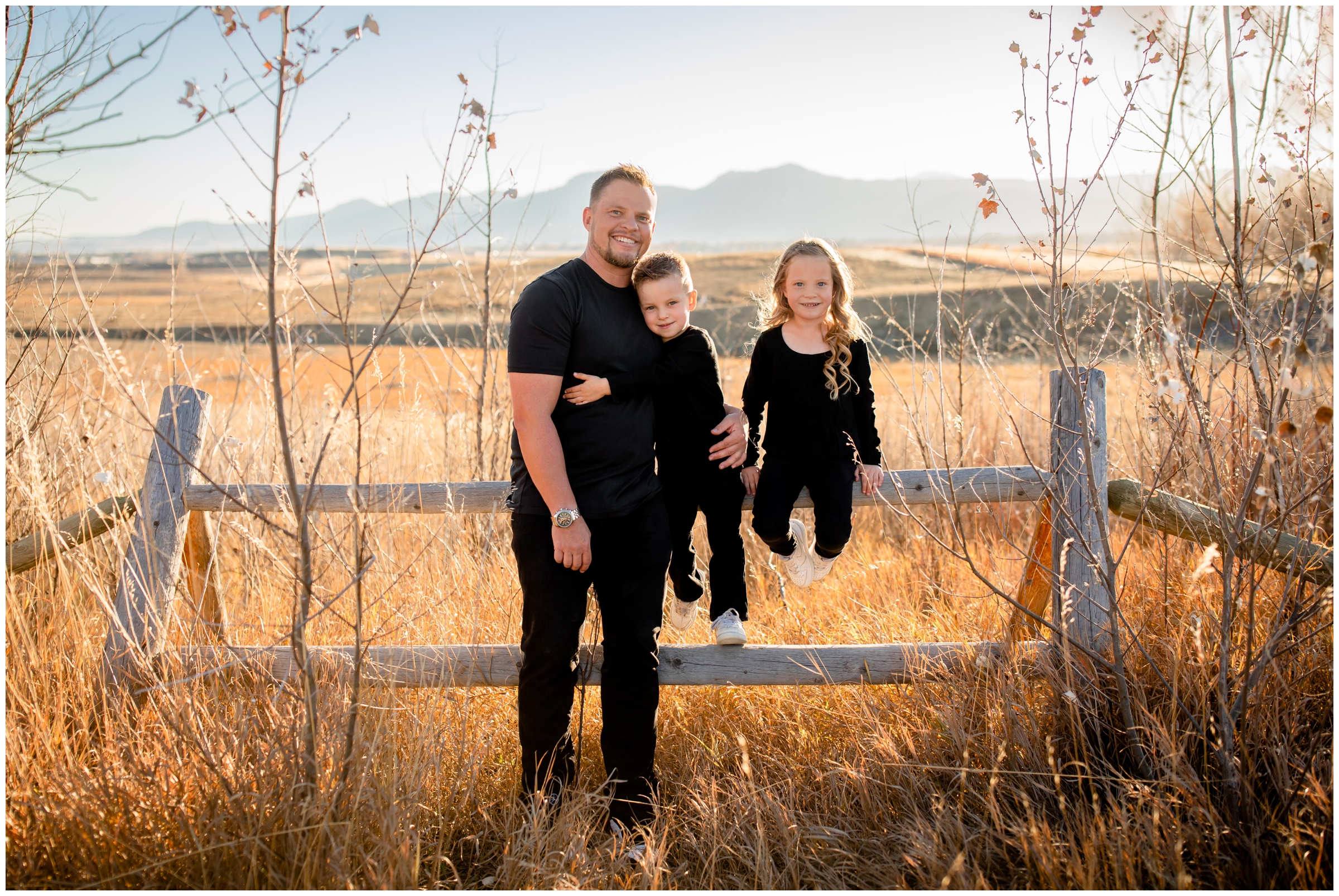 dad and kids sitting on wooden fence during Boulder family photography session at Coot Lake in Colorado 