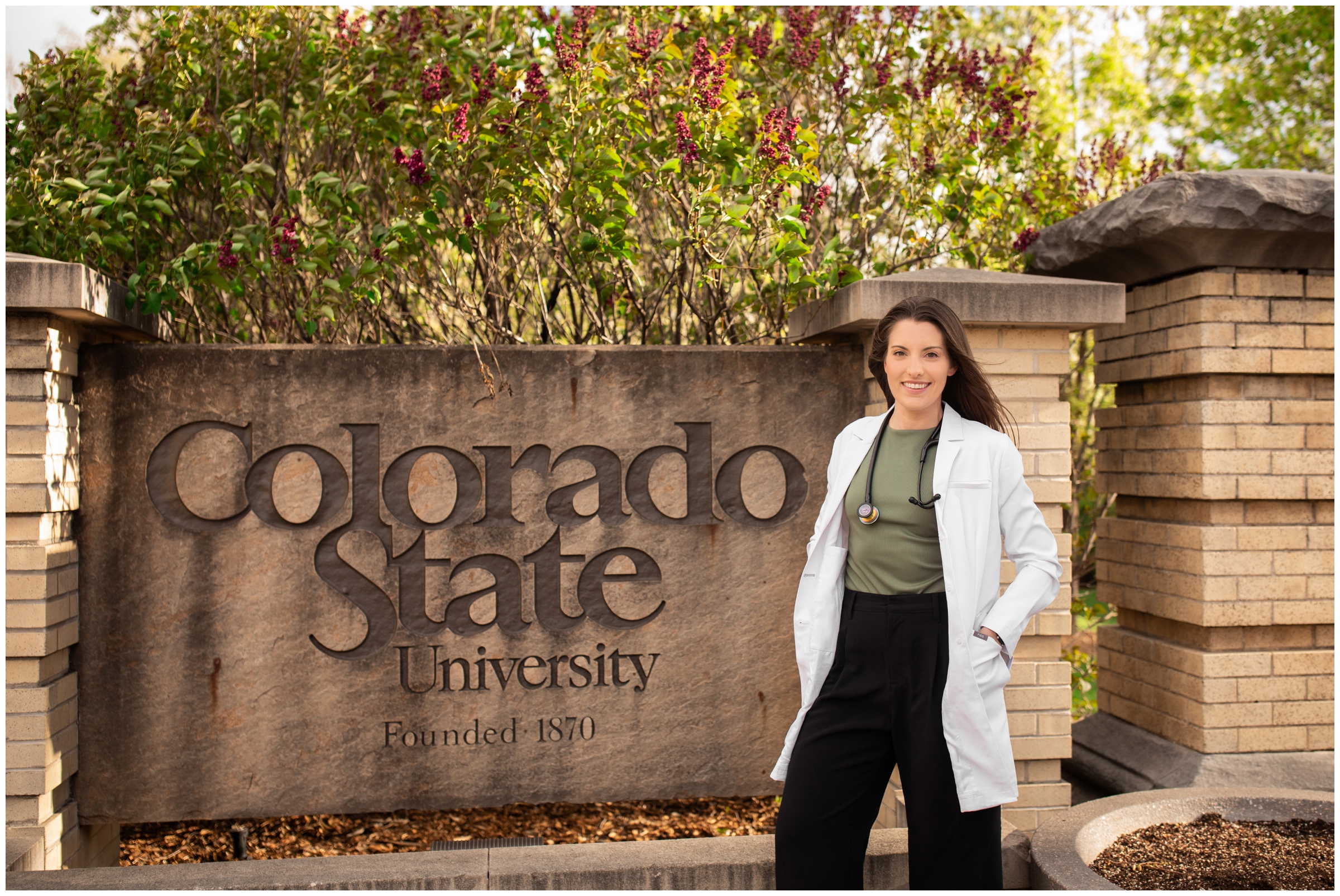 woman posing in front of colorado state university sign during spring graduation photography session by Plum Pretty Photography 